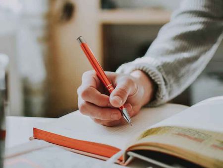 a student is writing in a notebook